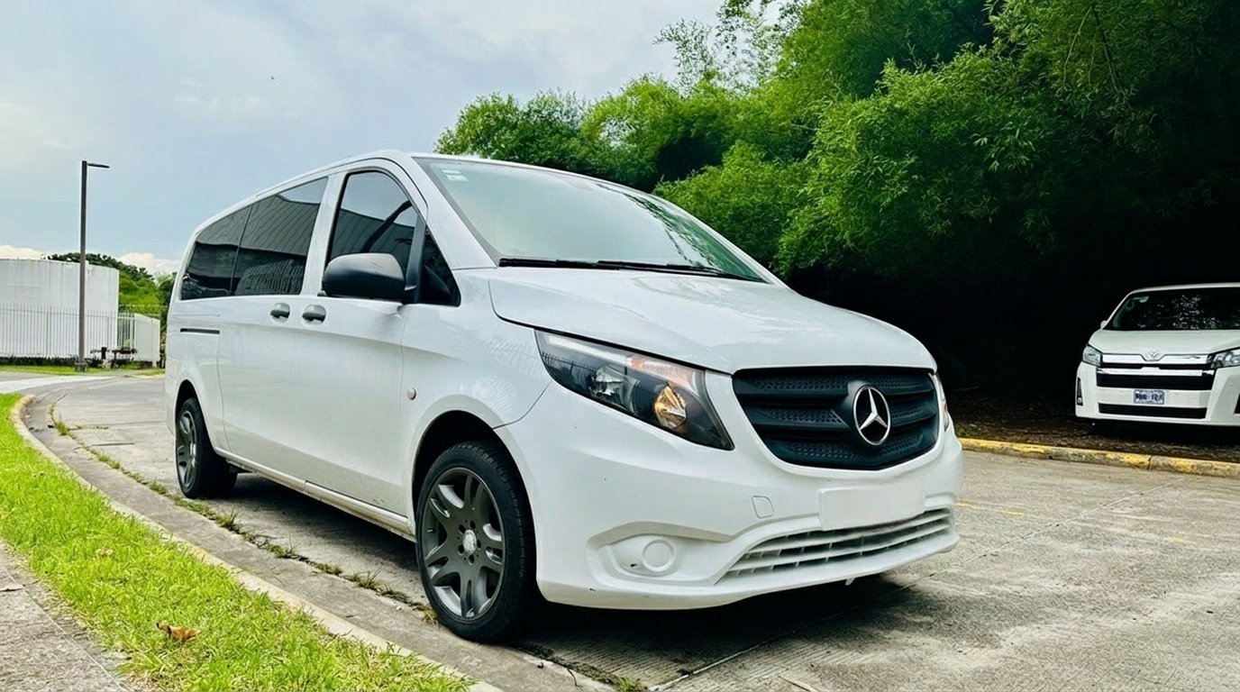 A spotless white Mercedes van from the Jacó Transport fleet, parked under the trees